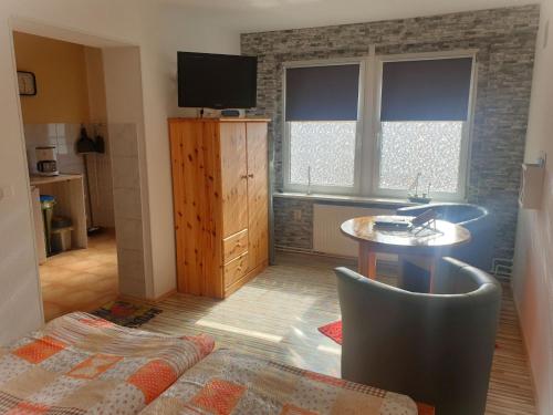 a living room with a table and a tv in it at Ferienwohnungen Seestraße in Sassnitz