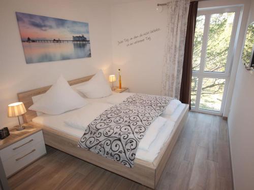 a bedroom with a bed and a large window at Villa Amelie App Seestern in Sassnitz