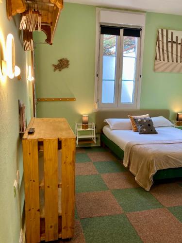 a bedroom with two beds and a table in it at L'Ecume des Jours in Soulac-sur-Mer