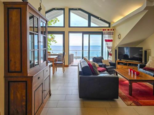 a living room with a couch and a tv at Villa Friede-Marie, Penthouse Lenea in Sassnitz