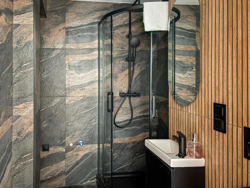 a bathroom with a glass shower and a sink at Apartament Bałandy 32 in Oświęcim