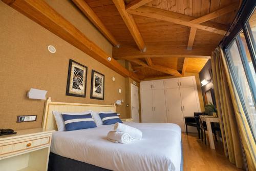 a bedroom with a bed with blue and white pillows at RoomRural Hotel Iru-Bide Lumbier in Lumbier