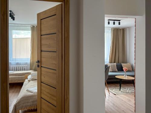 a door leading to a living room with a couch at Apartament Bałandy 32 in Oświęcim
