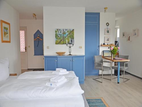 a bedroom with a white bed and a table with a laptop at Villa Monika App 7 in Sassnitz