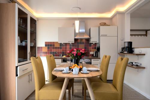 a kitchen with a table and chairs with flowers on it at Villa Nause-FeWo Buchenfreund mit Spa und Freizeit in Sassnitz