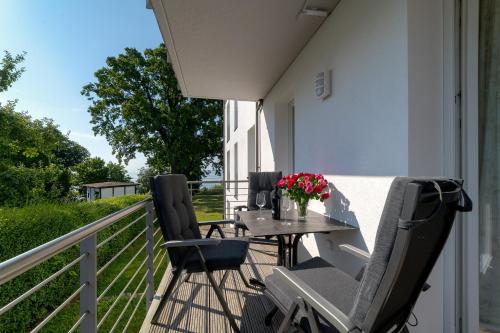 a patio with a table and chairs on a balcony at Villa Nause-FeWo Buchenfreund mit Spa und Freizeit in Sassnitz