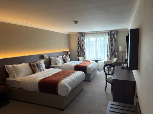 a hotel room with two beds and a table at Nuremore Estate in Carrickmacross