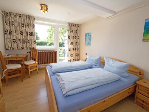a bedroom with two beds and a table and a window at Ferienzimmer zum Försterberg in Hagen