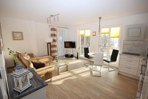 a living room with a couch and a table at Villa Amelie FeWo Seemoewe in Sassnitz