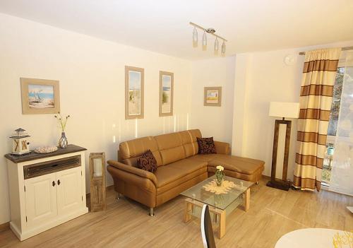 a living room with a couch and a table at Villa Amelie FeWo Seemoewe in Sassnitz