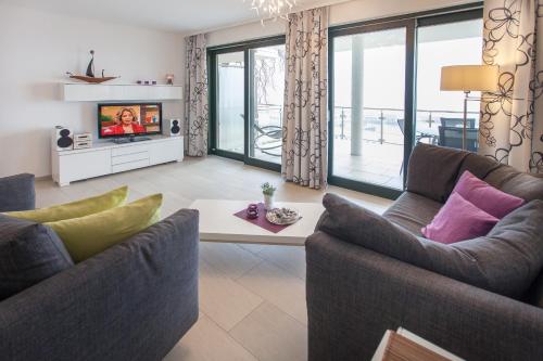 a living room with two couches and a tv at Villa Friede Marie FeWo Ariane in Sassnitz