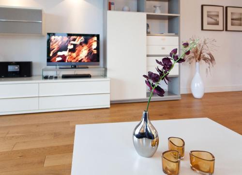a vase with flowers on a table in a living room at Villa Friede Marie FeWo Hannah in Sassnitz