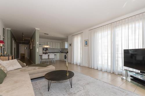 a living room with a couch and a flat screen tv at Villa Friede Marie FeWo Svea in Sassnitz