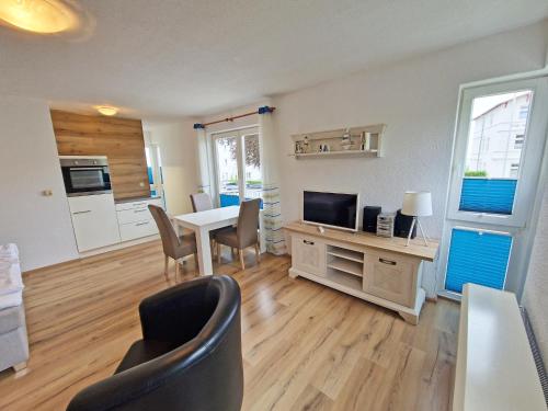 a living room with a table and chairs and a television at Villa Monika Backbord 2 in Sassnitz