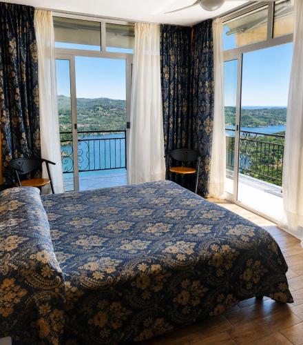 ein Schlafzimmer mit einem Bett und einem großen Fenster in der Unterkunft Hotel Panoramico SPA lago d'Orta Only Adults in Madonna del Sasso