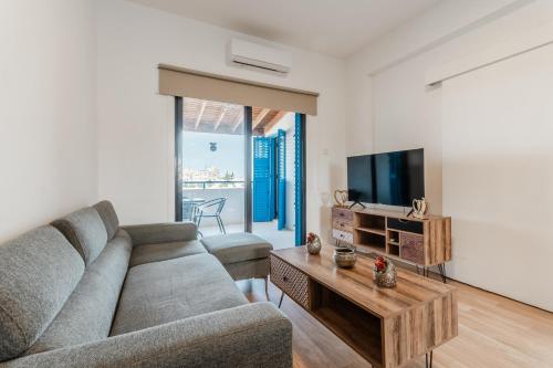 a living room with a couch and a tv at Beachside Hideaway Apartment, 200m to the Havana Beach in Pyla