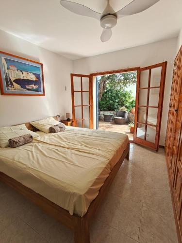 a bedroom with a large bed and a sliding glass door at Casa Mimosa, Calonge Cabanyes in Calonge