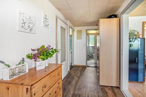a hallway with a wooden dresser with flowers on it at Ferienhof Knudsen in Pellworm