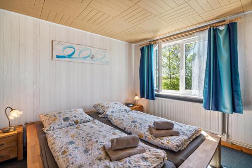 a bedroom with two beds and a window at Ferienhof Knudsen in Pellworm