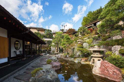 un jardín con un estanque frente a un edificio en Ishinoya Izunagaoka, en Izunokuni