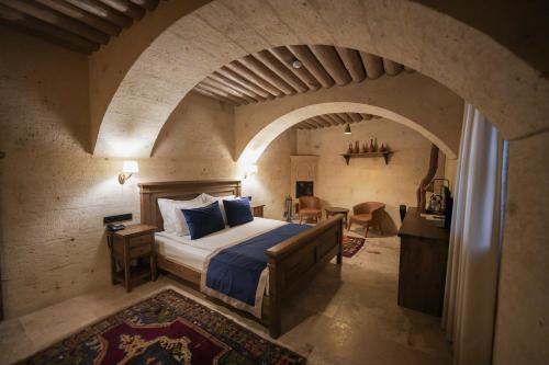 a bedroom with a bed in a room with an archway at Sinasos Evleri in Nevşehir