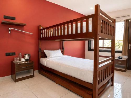 a bedroom with two bunk beds and a red wall at Kripalu Care Foundation in Vrindāvan