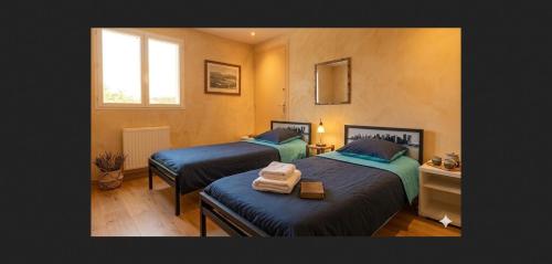 a bedroom with two beds and a window at Volca'séjour in Orcines