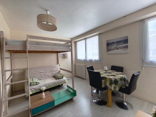 a small room with a bunk bed and a table at Studio cosy proche plage & centre in Le Havre