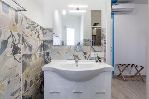 a bathroom with a sink and a mirror at NURAS - Affittacamere L'Azzurra - Double bedrooms private bathroom and seaview solarium in Sorso