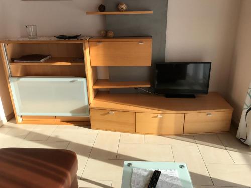 a living room with a tv on a wooden entertainment center at Haus "Charly" in Nauders