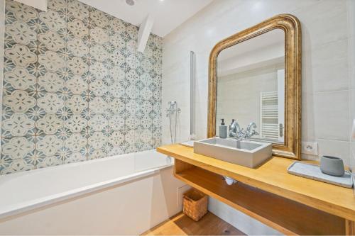 a bathroom with a sink and a mirror at Villa typique - piscine et terrasse in La Teste-de-Buch