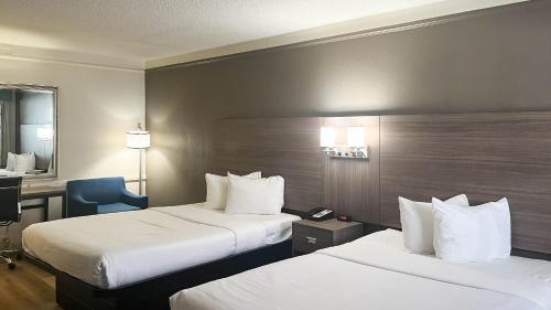a hotel room with two beds and a desk at Motel 6 Aurora, CO - Medical Center in Aurora