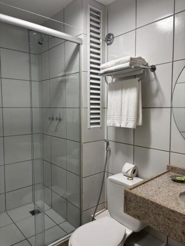 a bathroom with a toilet and a glass shower at Gran Lençóis in Barreirinhas