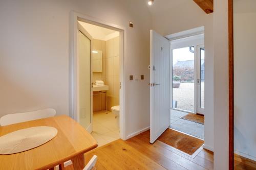 a dining room with a table and a bathroom at The Suites at Pannells Ash in Castle Hedingham