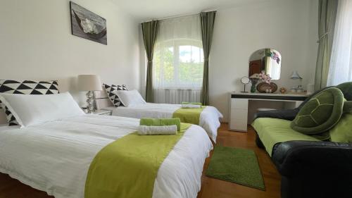 a bedroom with two beds and a couch and a window at Meszko Park House Budapest in Budapest