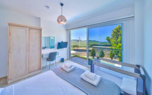a bedroom with a bed and a large window at Nergiz Villas in Kaş