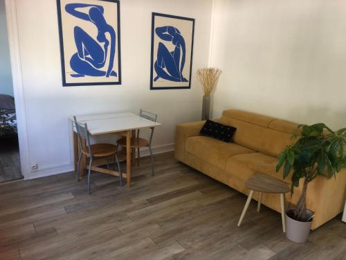 a living room with a couch and a table at Maisonnette rurale de charme in Plessis-Saint-Benoist