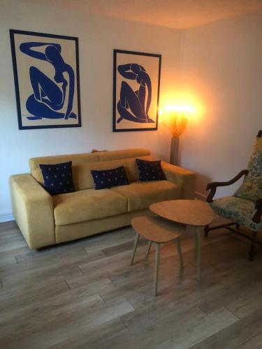 a living room with a couch and a table at Maisonnette rurale de charme in Plessis-Saint-Benoist