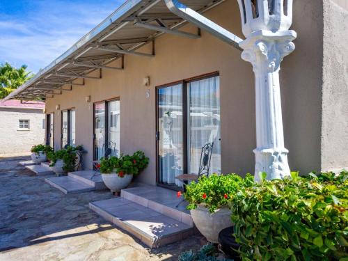 a building with some potted plants and a pole at Hazeldene Accommodation in Colesberg