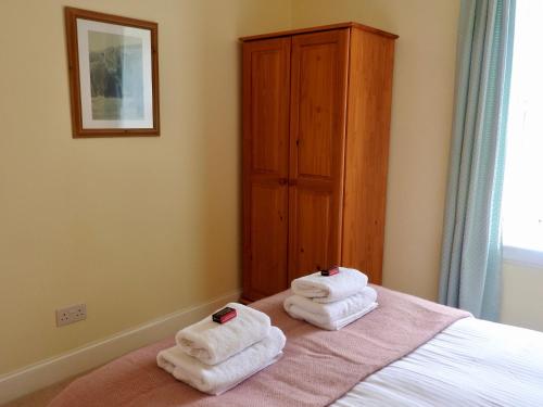 a bedroom with towels sitting on top of a bed at Foxglove Cottage in Killean