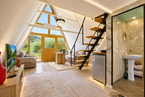 a room with a loft conversion with a staircase and a living room at Villa Olivia in Elbasan