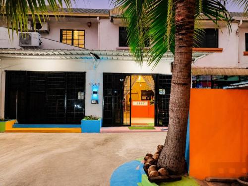 a building with a palm tree in front of it at Sunset Seaview Bay Villa in Putatan
