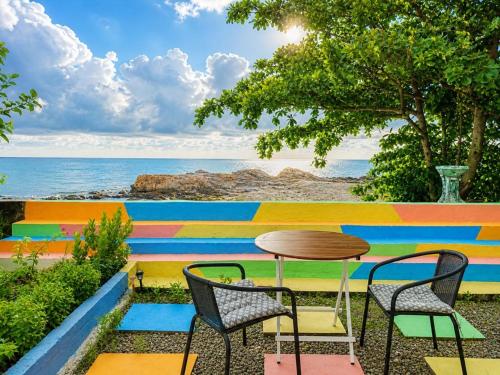 a table and chairs in front of a colorful wall at Sunset Seaview Bay Villa in Putatan