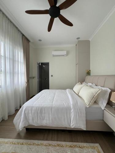 a bedroom with a bed with a ceiling fan at Elite Cozy Home 5BR5B, BBQ, Karaoke, Netflix, Near MITC in Ayer Keroh