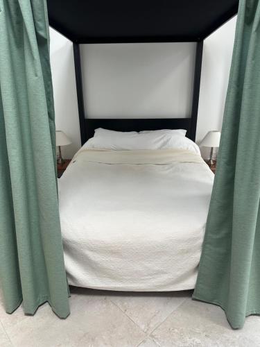 a bed with green curtains in a bedroom at The Studio in Willerby