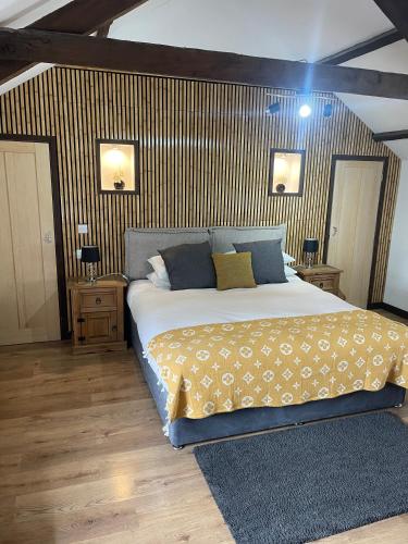 a bedroom with a large bed and two night stands at The Stables in Llandysul