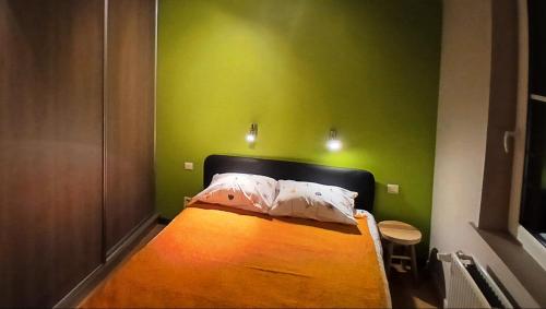 a bedroom with a bed with a green wall at B2B Apartment Creamundi in Lokeren