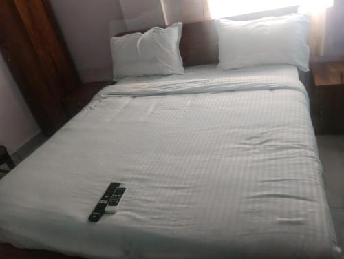 a white bed with a remote control on it at crown crest condos in Chengalpattu