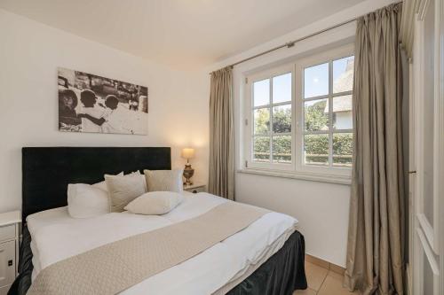 a bedroom with a large bed and a window at Reethus am Küstenwald in Koserow