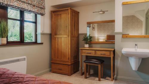 a bathroom with a sink and a desk with a sink at Wansfell Cottage At Windermere Marina Village in Bowness-on-Windermere